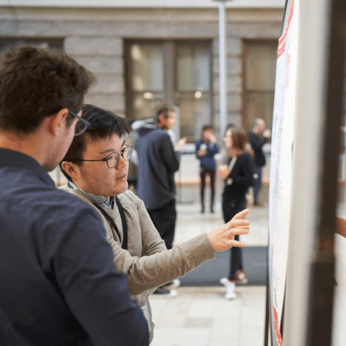 Two people discussing a scientific poster